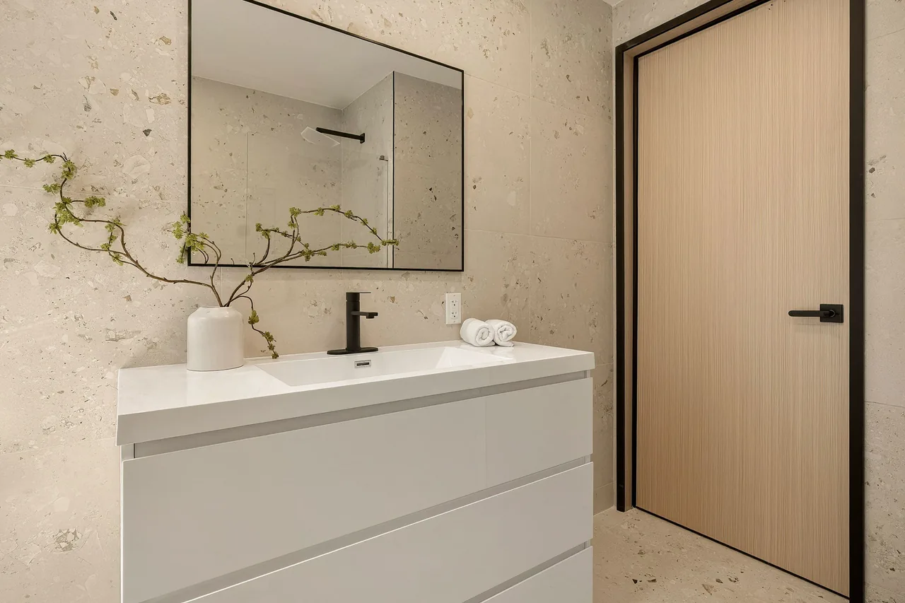 Matching door and dark frame beside the bathroom vanity.
