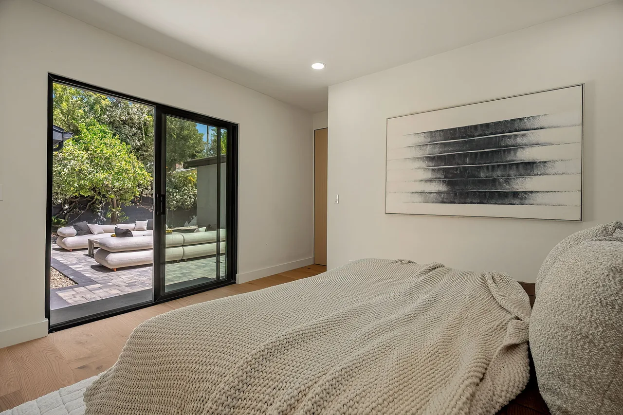 A sliding glass opening connects the bedroom to the courtyard.