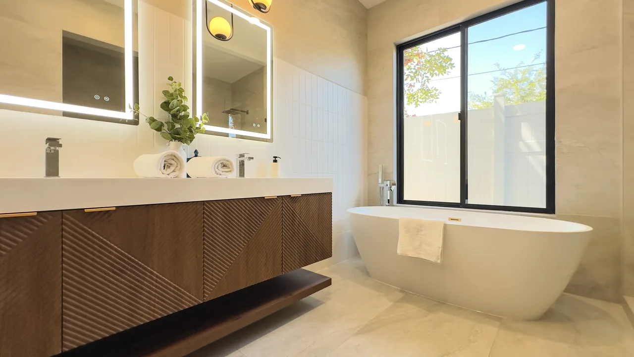 Black-framed glazing beside the freestanding bath.