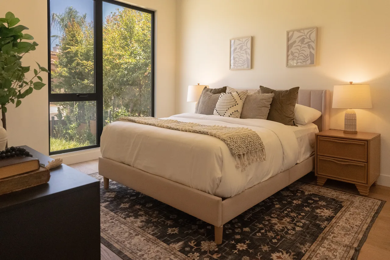 Tall black-framed glazing brings daylight into the bedroom.
